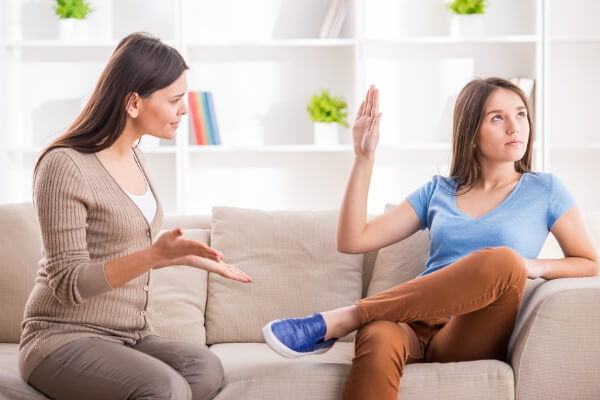 teenage daughter not listening to mother with talk to the hand gesture