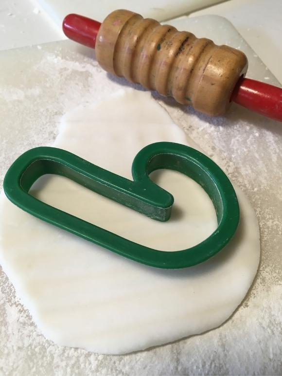 white homemade clay with a small rolling pin and cookie cutter