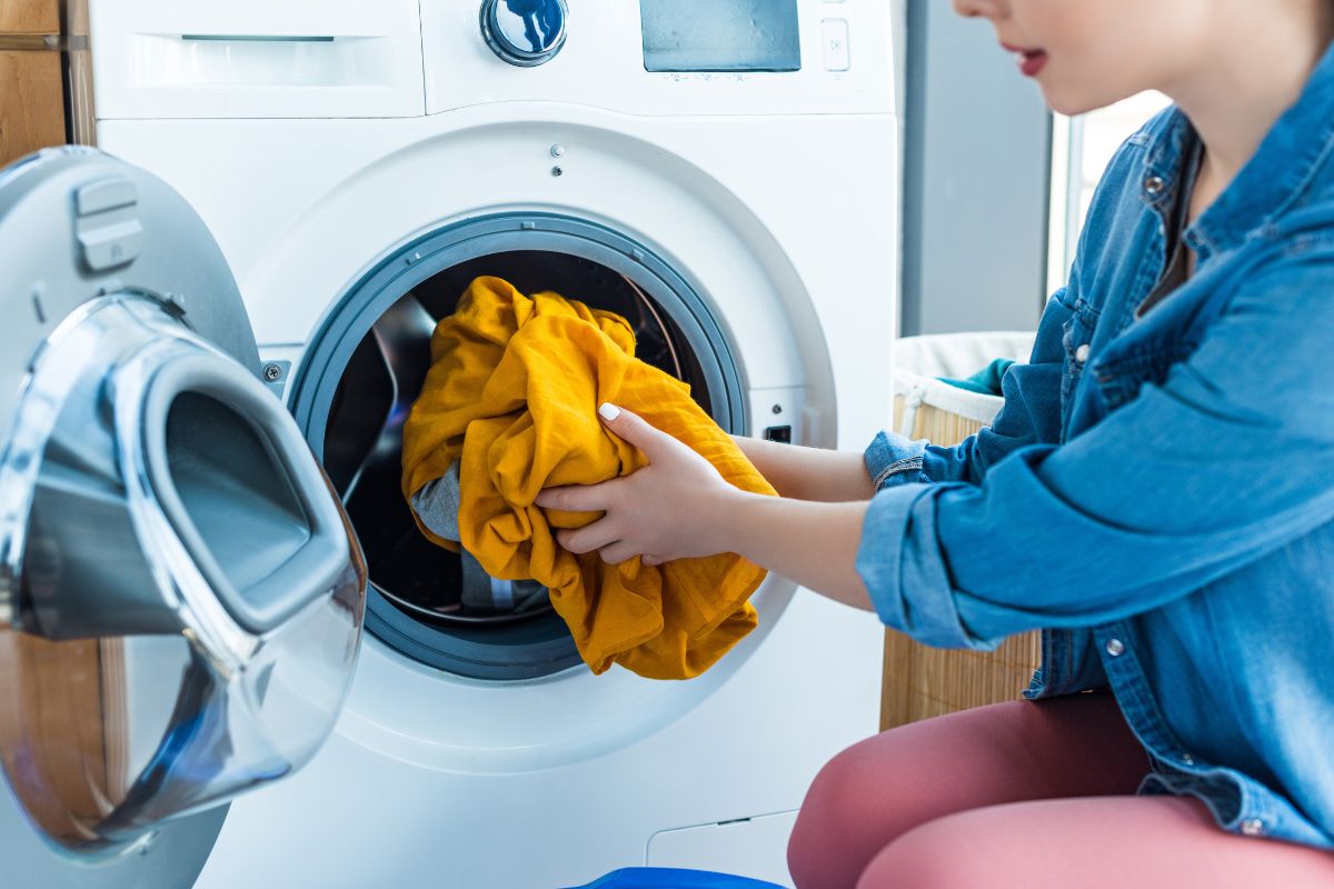 woman putting laundry in washer