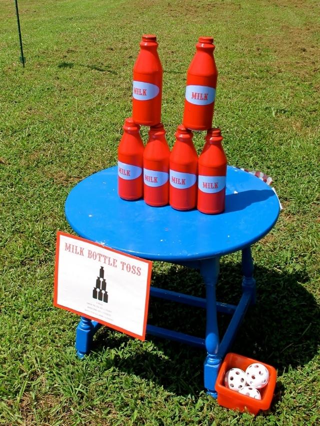 milk bottle toss game for a carnival birthday party set up on a small table